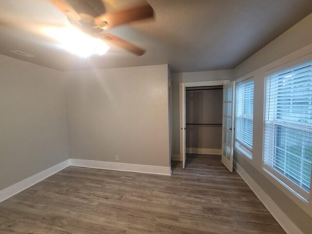 2301 45th St, Galveston, TX 77551 - unfurnished bedroom featuring dark wood-style floors, a ceiling fan, and a closet