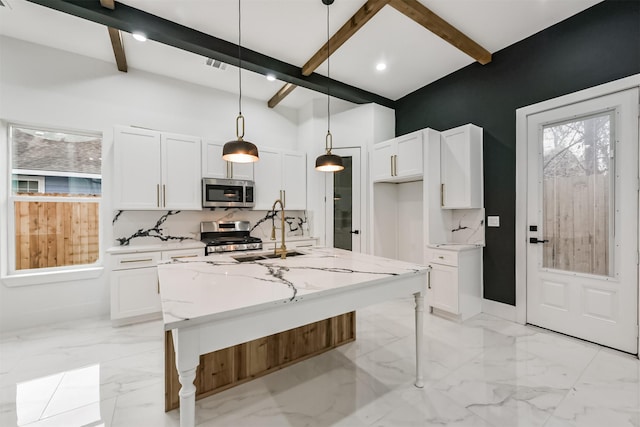 613 Melbourne St, Houston, TX 77022 - kitchen with stainless steel appliances, beamed ceiling, white cabinetry, light stone countertops, and decorative light fixtures