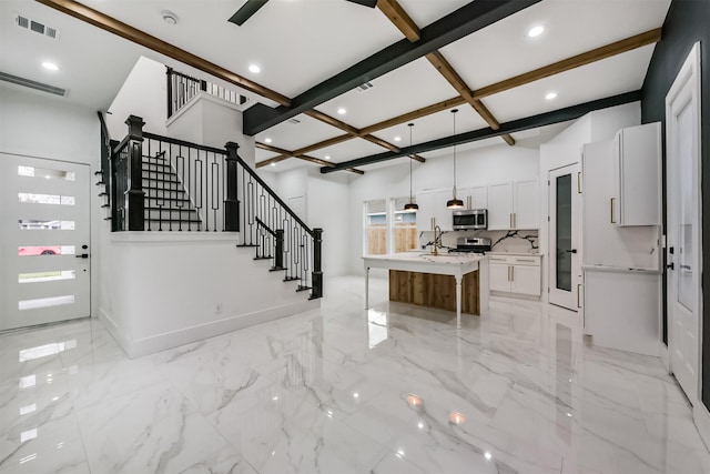 613 Melbourne St, Houston, TX 77022 - kitchen with stainless steel microwave, coffered ceiling, beam ceiling, light countertops, and white cabinetry