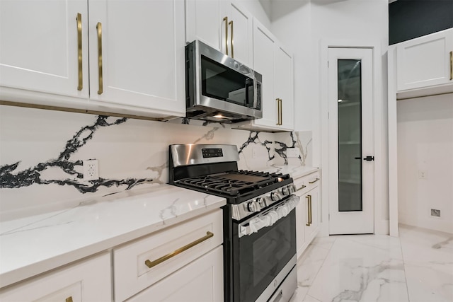 613 Melbourne St, Houston, TX 77022 - kitchen with appliances with stainless steel finishes, white cabinetry, light marble finish flooring, light stone countertops, and backsplash