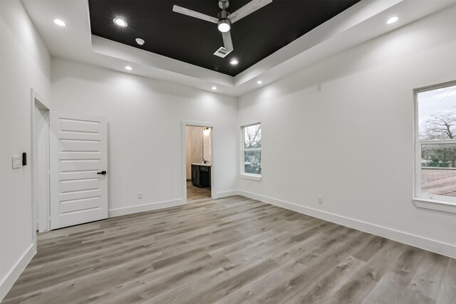 613 Melbourne St, Houston, TX 77022 - unfurnished bedroom featuring a raised ceiling, light wood-style floors, recessed lighting, ensuite bath, and a high ceiling