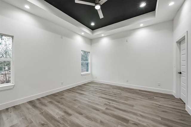 613 Melbourne St, Houston, TX 77022 - unfurnished room with ceiling fan, a tray ceiling, healthy amount of natural light, wood finished floors, and recessed lighting