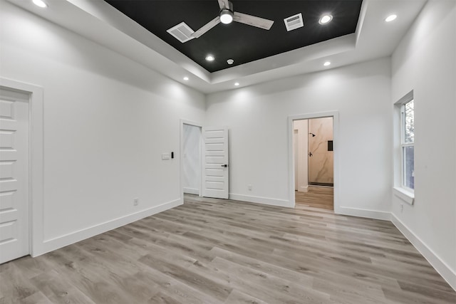 613 Melbourne St, Houston, TX 77022 - empty room with a raised ceiling, light wood-type flooring, recessed lighting, a high ceiling, and a ceiling fan