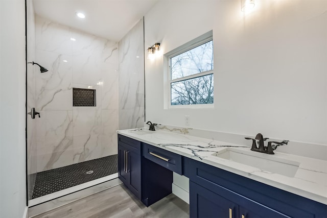 613 Melbourne St, Houston, TX 77022 - bathroom featuring a marble finish shower, double vanity, and wood finished floors