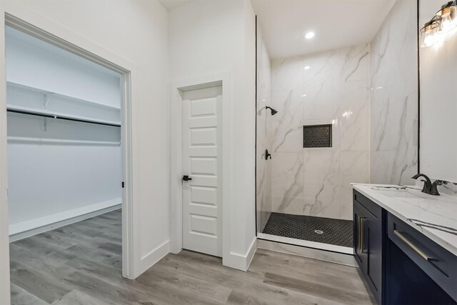 613 Melbourne St, Houston, TX 77022 - full bath with a marble finish shower, vanity, a walk in closet, wood finished floors, and recessed lighting