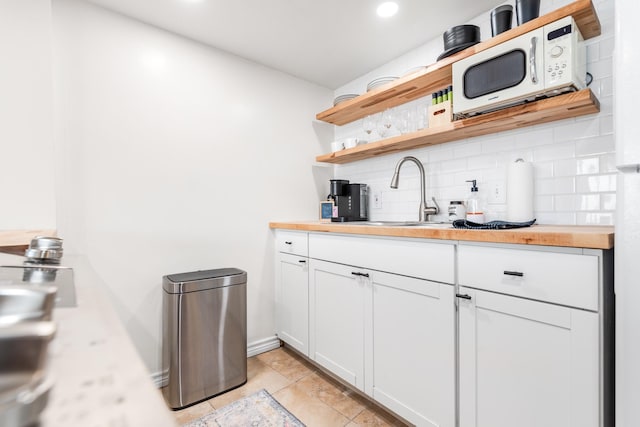 14401 Commodores Dr Unit 104, Corpus Christi, TX 78418 - kitchen with open shelves, white microwave, tasteful backsplash, wood counters, and recessed lighting