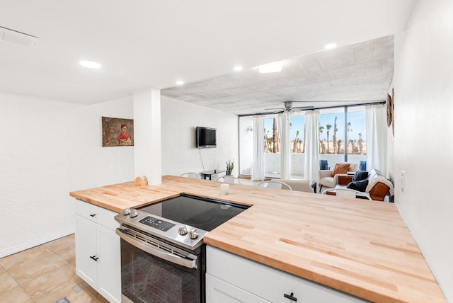 14401 Commodores Dr Unit 104, Corpus Christi, TX 78418 - kitchen featuring butcher block countertops, stainless steel electric range oven, open floor plan, white cabinetry, and ceiling fan