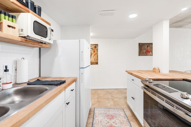 14401 Commodores Dr Unit 104, Corpus Christi, TX 78418 - kitchen featuring wooden counters, white appliances, backsplash, white cabinets, and recessed lighting