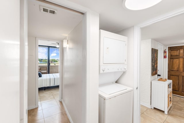 14401 Commodores Dr Unit 104, Corpus Christi, TX 78418 - laundry area featuring estacked washer and dryer, light tile patterned flooring, and ceiling fan