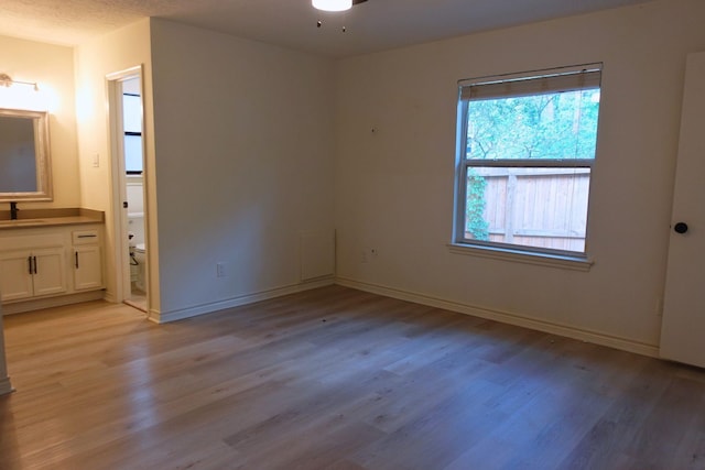 12227 Gun Oak Pl, The Woodlands, TX 77380 - unfurnished bedroom featuring light wood-style flooring and connected bathroom