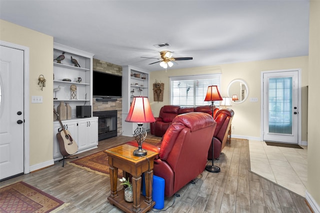80 Indian Hbr, Trinity, TX 75862 - living area with a large fireplace, light wood-style floors, ceiling fan, and built in shelves
