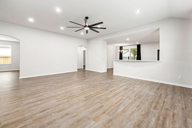 11323 Cora Ln, Willis, TX 77318 - unfurnished living room with arched walkways, recessed lighting, wood finished floors, and ceiling fan