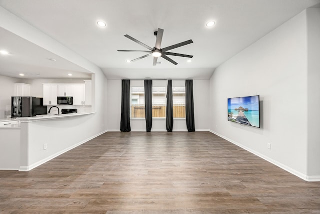11323 Cora Ln, Willis, TX 77318 - unfurnished living room with ceiling fan, recessed lighting, wood finished floors, and vaulted ceiling