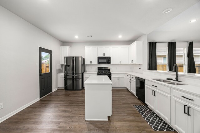 11323 Cora Ln, Willis, TX 77318 - kitchen featuring black appliances, a center island, dark wood-style floors, white cabinetry, and light countertops