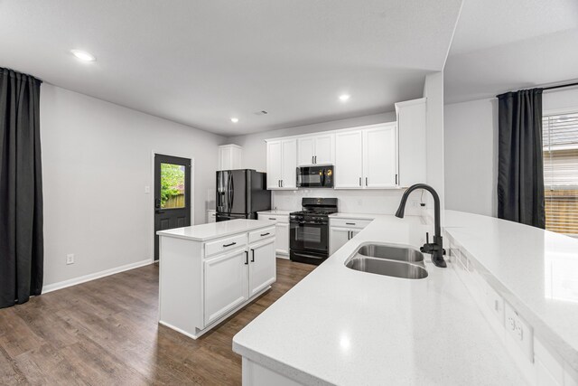 11323 Cora Ln, Willis, TX 77318 - kitchen with black appliances, a center island, dark wood finished floors, recessed lighting, and white cabinetry