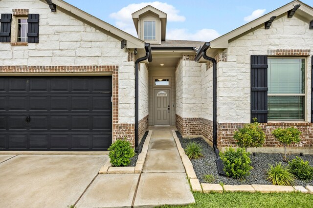 11323 Cora Ln, Willis, TX 77318 - view of front of home with stone siding, concrete driveway, brick siding, and a garage