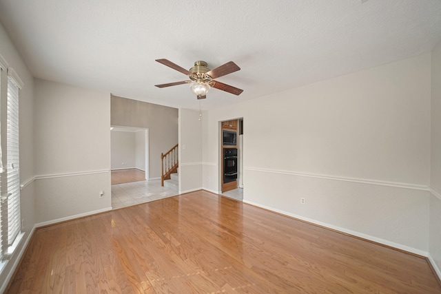 8602 Canyon Pine Dr, Spring, TX 77379 - unfurnished room with ceiling fan, wood finished floors, and stairway
