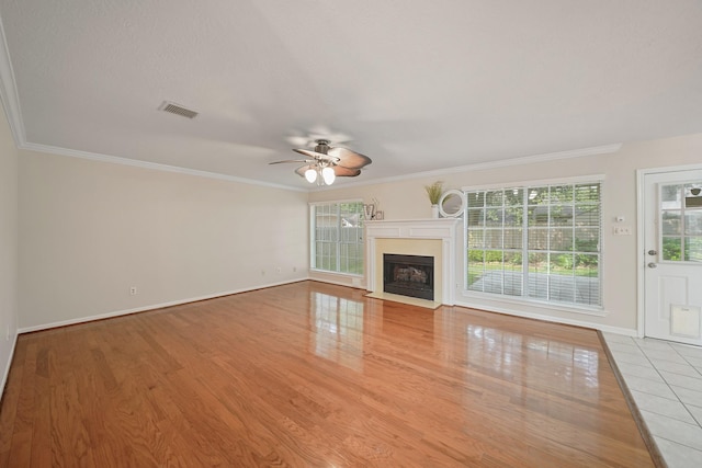 8602 Canyon Pine Dr, Spring, TX 77379 - unfurnished living room featuring a ceiling fan, wood finished floors, ornamental molding, and a fireplace with flush hearth