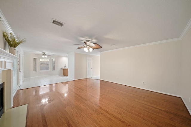 8602 Canyon Pine Dr, Spring, TX 77379 - unfurnished living room featuring a ceiling fan, a fireplace with flush hearth, crown molding, and wood finished floors