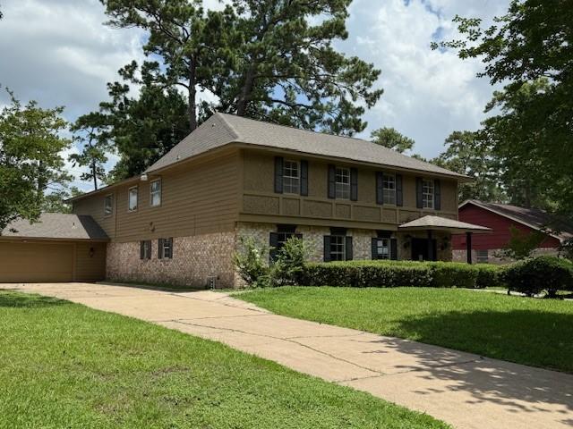 5914 Foresthaven Dr, Houston, TX 77066 - view of front of house featuring concrete driveway, a front yard, stone siding, and an attached garage