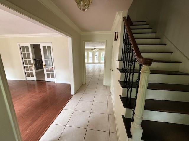 5914 Foresthaven Dr, Houston, TX 77066 - stairway with french doors, ornamental molding, tile patterned flooring, and a ceiling fan