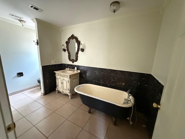 5914 Foresthaven Dr, Houston, TX 77066 - full bath with ornamental molding, a freestanding bath, vanity, tile patterned flooring, and tile walls