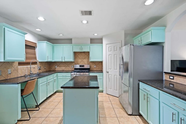 10919 Barker View Dr, Cypress, TX 77433 - kitchen featuring appliances with stainless steel finishes, a center island, dark stone countertops, decorative backsplash, and light tile patterned floors