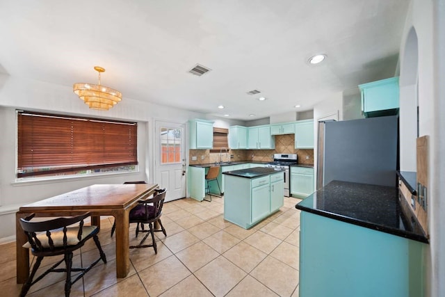 10919 Barker View Dr, Cypress, TX 77433 - kitchen featuring appliances with stainless steel finishes, tasteful backsplash, light tile patterned floors, a kitchen island, and pendant lighting