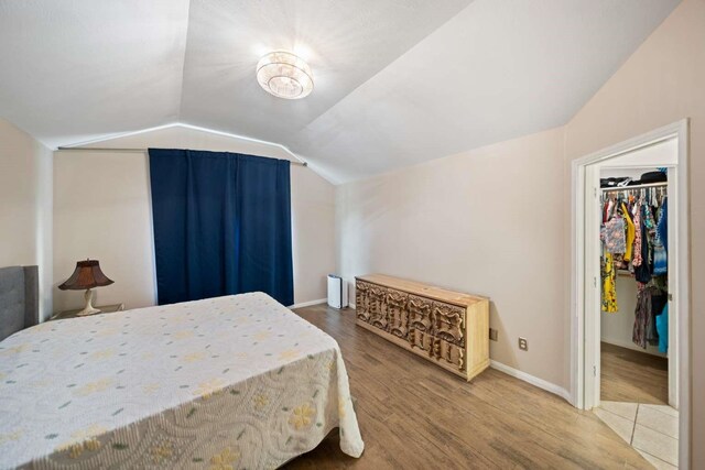 10919 Barker View Dr, Cypress, TX 77433 - bedroom featuring vaulted ceiling, wood finished floors, and a spacious closet