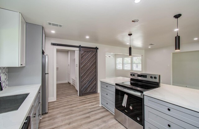 10415 Westray St, Houston, TX 77043 - kitchen with appliances with stainless steel finishes, gray cabinets, a barn door, light wood-style floors, and recessed lighting