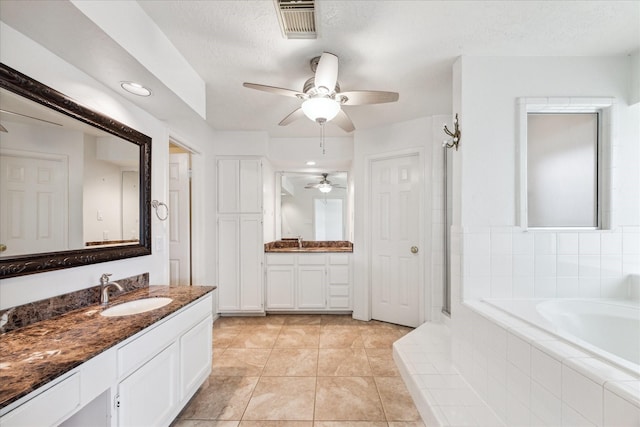 12823 Birch Falls Rd, Houston, TX 77065 - bathroom with a garden tub, two vanities, ceiling fan, tile patterned floors, and a shower