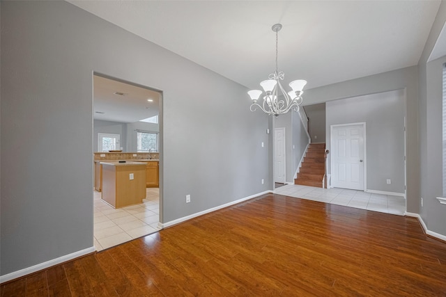 5403 Round Hollow Ct, Katy, TX 77494 - empty room featuring light wood-style flooring, stairway, and a chandelier
