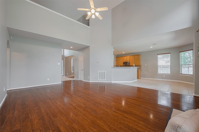 5403 Round Hollow Ct, Katy, TX 77494 - unfurnished living room with light wood finished floors, a ceiling fan, and a towering ceiling