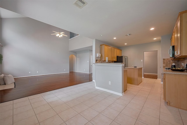 5403 Round Hollow Ct, Katy, TX 77494 - kitchen with stainless steel appliances, open floor plan, light tile patterned floors, arched walkways, and tasteful backsplash