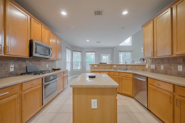 5403 Round Hollow Ct, Katy, TX 77494 - kitchen featuring appliances with stainless steel finishes, a kitchen island, a peninsula, light tile patterned floors, and tasteful backsplash