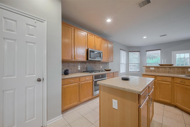 5403 Round Hollow Ct, Katy, TX 77494 - kitchen featuring appliances with stainless steel finishes, light tile patterned flooring, decorative backsplash, a kitchen island, and recessed lighting