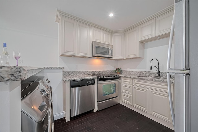 2333 Bering Dr Unit 334, Houston, TX 77057 - kitchen with appliances with stainless steel finishes, dark wood-style flooring, washing machine and clothes dryer, light stone countertops, and white cabinets