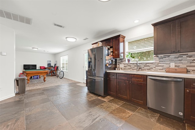 129 Breezy Shore Ct, Dickinson, TX 77539 - kitchen with stainless steel appliances, billiards table, light countertops, decorative backsplash, and dark brown cabinetry
