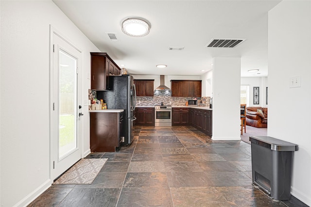 129 Breezy Shore Ct, Dickinson, TX 77539 - kitchen featuring stainless steel appliances, light countertops, wall chimney exhaust hood, backsplash, and dark brown cabinets