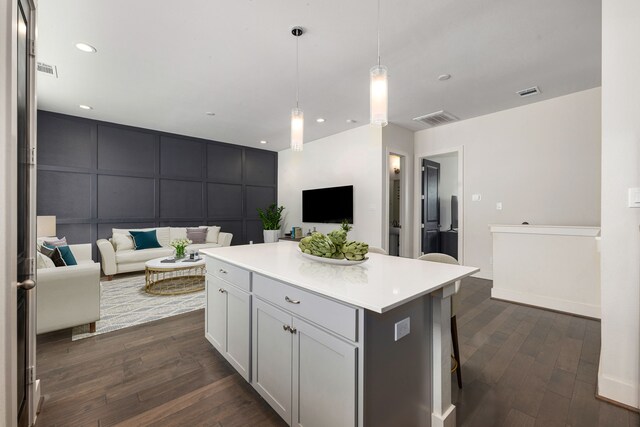 6033 Cypress St, Houston, TX 77074 - kitchen with a decorative wall, open floor plan, dark wood-style floors, a center island, and light countertops
