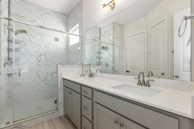 6033 Cypress St, Houston, TX 77074 - full bathroom featuring double vanity, a marble finish shower, and wood finished floors