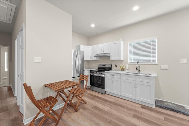 1026 Theresa St, Houston, TX 77051 - kitchen with appliances with stainless steel finishes, under cabinet range hood, light wood-style floors, white cabinetry, and light countertops