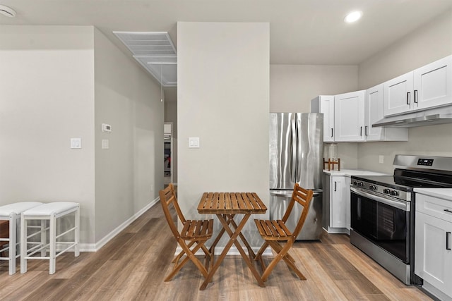 1026 Theresa St, Houston, TX 77051 - kitchen featuring appliances with stainless steel finishes, under cabinet range hood, light wood-type flooring, white cabinets, and recessed lighting