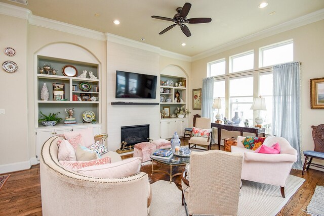 2230 Lakeshore Edge Dr, Houston, TX 77080 - living area with a large fireplace, a ceiling fan, dark wood finished floors, built in shelves, and ornamental molding