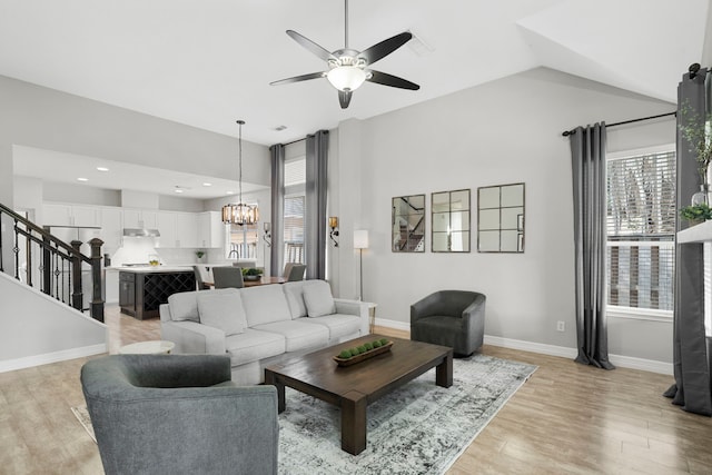 3423 Velasco Ct, Missouri City, TX 77459 - living area with ceiling fan, a chandelier, light wood-type flooring, and stairway