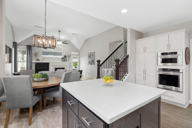 3423 Velasco Ct, Missouri City, TX 77459 - kitchen with healthy amount of natural light, lofted ceiling, a chandelier, double oven, and white cabinetry