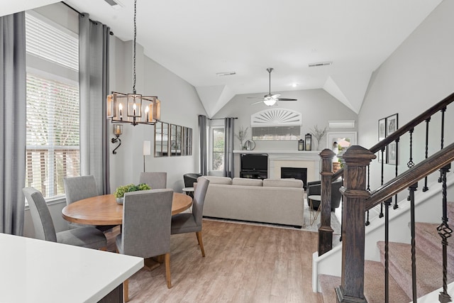 3423 Velasco Ct, Missouri City, TX 77459 - dining area featuring stairway, light wood-style flooring, a fireplace, a chandelier, and vaulted ceiling
