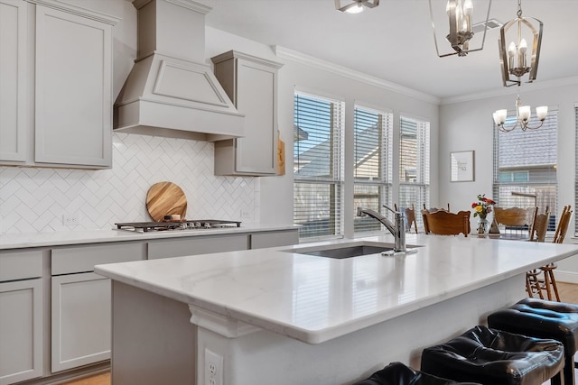 10059 Preserve Way, Conroe, TX 77385 - kitchen featuring custom range hood, a chandelier, tasteful backsplash, ornamental molding, and a kitchen bar