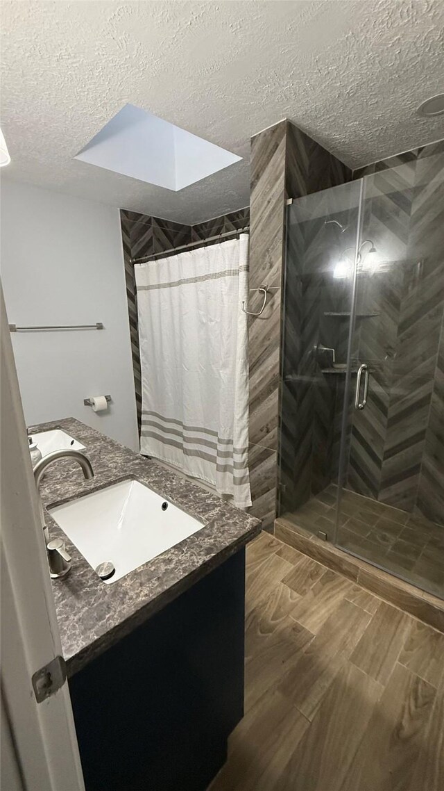 6018 Beaconridge Dr, Houston, TX 77053 - full bathroom featuring a textured ceiling, a shower stall, vanity, and wood finished floors