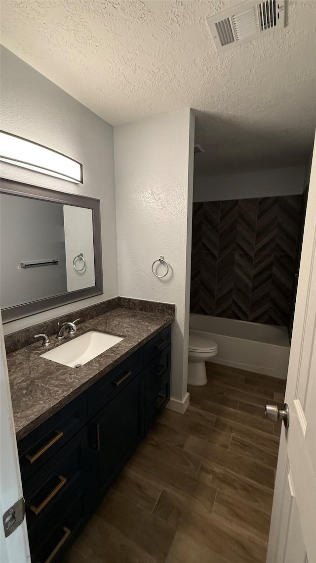 6018 Beaconridge Dr, Houston, TX 77053 - bathroom with vanity, a textured ceiling, wood finished floors, and shower / washtub combination